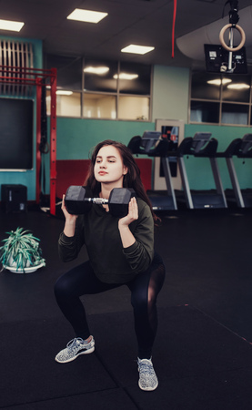 athletic woman doing exercise with dumbbells in gymの写真素材