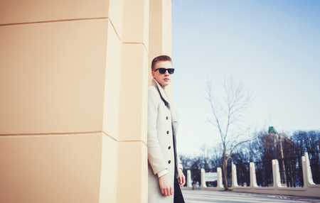 Handsome sexy man in coat posing on the street with copy spaceの写真素材