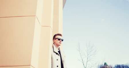 Handsome young man outdoor in fashion coat and sunglasses. copys paceの写真素材