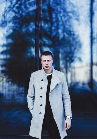 Young handsome man in stylish coat outdoorsの写真素材