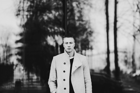 fashion man posing in stylish coatの写真素材