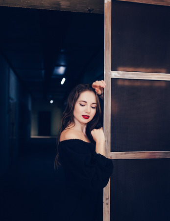 Beautiful sensual lady in clothes stands by the grunge wall. Fashion.の写真素材