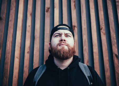 bearded man traveler with backpack on wall backgroundの写真素材