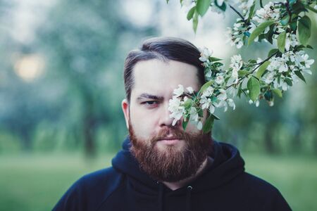 Handsome bearded man looking at camera in spring parkの写真素材