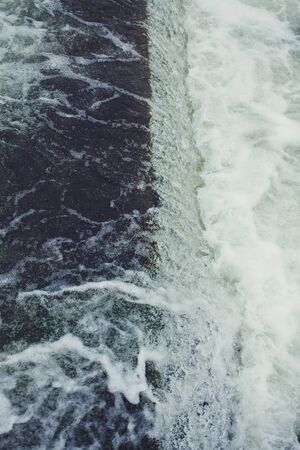 rapid flow of water close-up. a small dam with a waterfallの写真素材