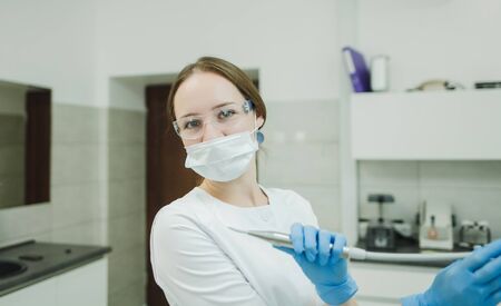 woman dentist in mask and glasses in the workplaceの写真素材