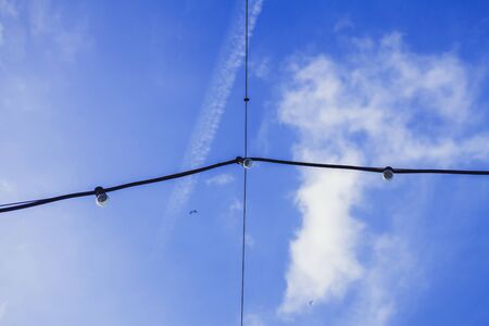 hanging electric lamps against the blue skyの写真素材