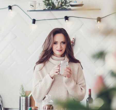 Happy woman drinking coffee in early morning standing at kitchenの写真素材
