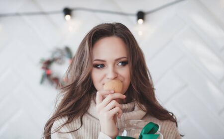 cute woman smelling a sweet cookie for Christmasの写真素材