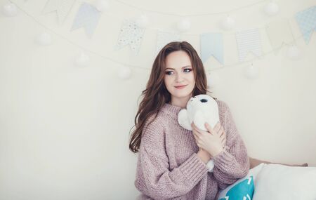 beautiful woman in warm sweater in decorated christmas roomの写真素材