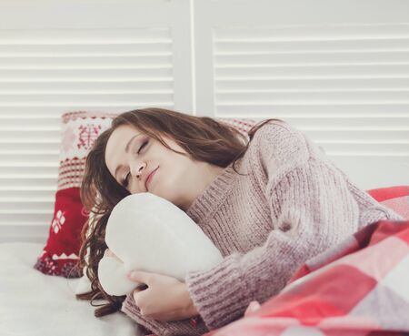 Woman sleeping. Beautiful young woman sleeping in bed with plush toyの写真素材