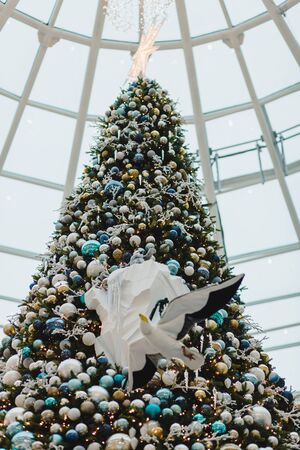 tall Christmas tree with bright star in shopping Mallの写真素材