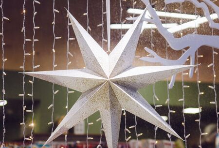 large Christmas star hangs in a shop windowの写真素材