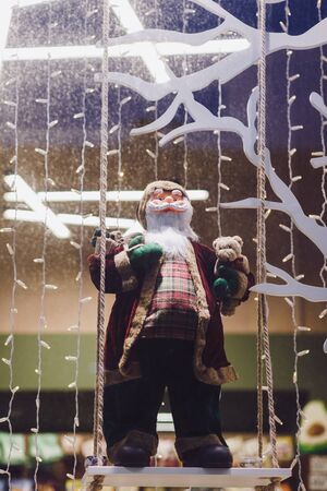 Santa Claus doll with beard on Christmas decorated showcaseの写真素材