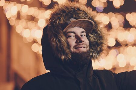 happy bearded man smiling on the background of christmas lightsの写真素材