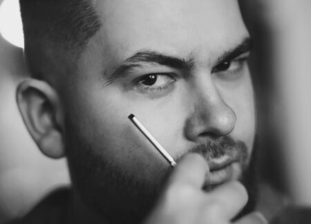 black and white portrait of a brutal bearded man with a dangerous bladeの写真素材