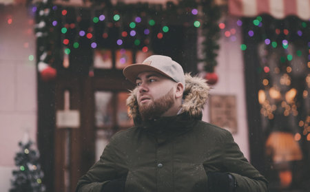 Winter lifestyle portrait of handsome man with beard walking in the city