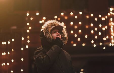 Beautiful bearded young man smoking on the street in an urban settingの写真素材