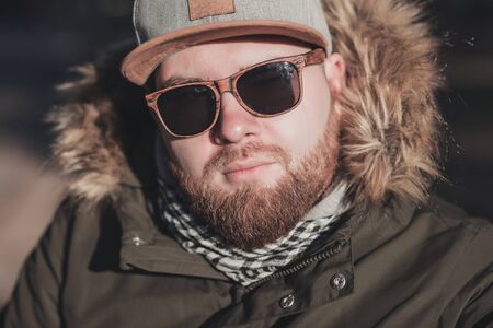 close up portrait of a bearded stylish man in sunglasses and a capの写真素材