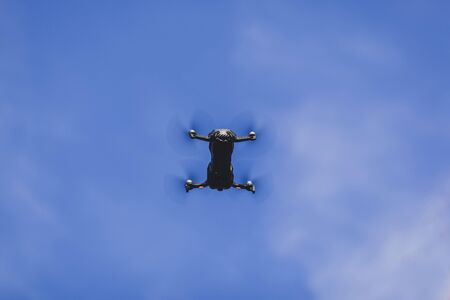 Small drone flying in blue skyの写真素材