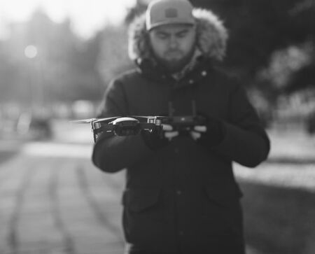 man with a remote control controls a flying drone in the Parkの写真素材