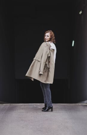 Outdoor lifestyle fashion portrait of elegant woman wearing trendy coatの写真素材