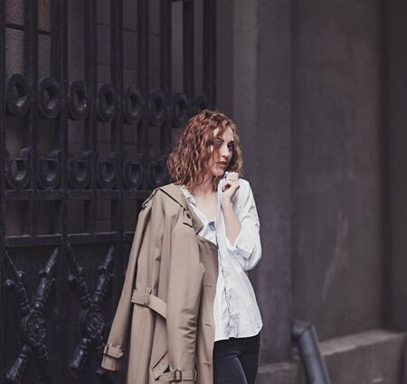 Portrait of happy woman in coat standing outsideの写真素材