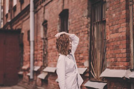 portrait  young woman near an old brick buildingの写真素材