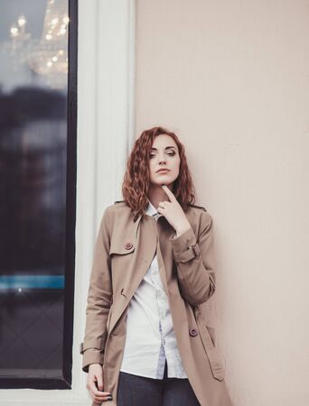 portrait of pretty girl with curly hair looking to camera in cityの写真素材