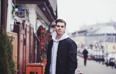 Young stylish guy in a bomber jacket smilesの写真素材