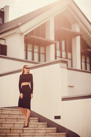 office woman dressed in strict black pencil skirt and top. looking awayの写真素材