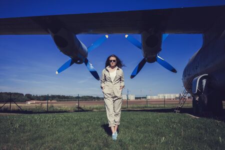female pilot in overalls and Aviator glasses on the background of the plane's bladesの写真素材