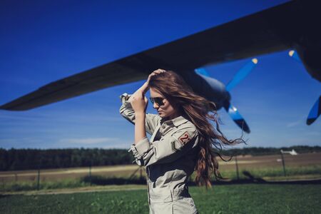 beautiful woman in sunglasses aviators near the planeの写真素材