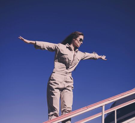 Happy girl in sunglasses on contrasted blue sky background. Urban fashion woman outdoorsの写真素材