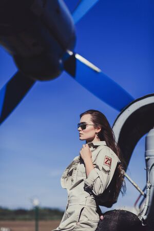fashion portrait military woman in uniform and sunglasses near airplaneの写真素材