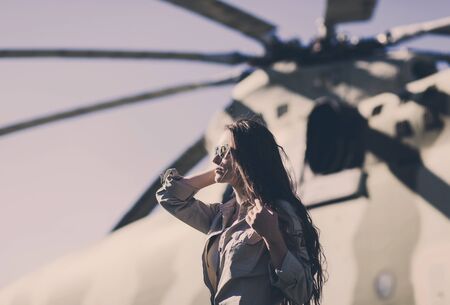 Fashion woman in uniform ready to start. Helicopter in the background.の写真素材