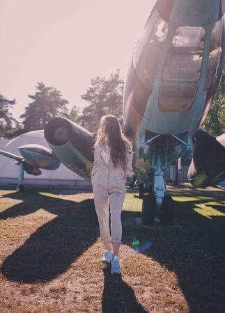 Stylish brunette woman in trendy sunglasses posing near aircraftの写真素材
