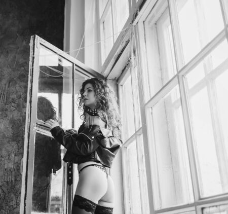 sexy lady in leather jacket  posing near windowsの写真素材