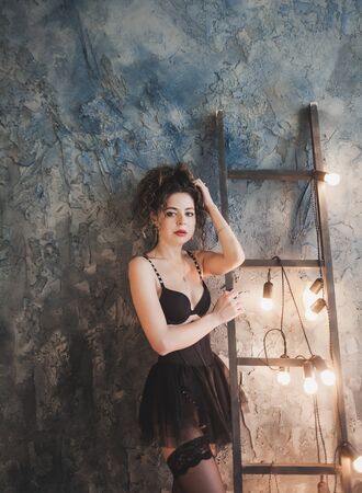 portrait of a beautiful sexy woman wearing a lingerie and black stocking. Fashion, style, beauty, interiorの写真素材