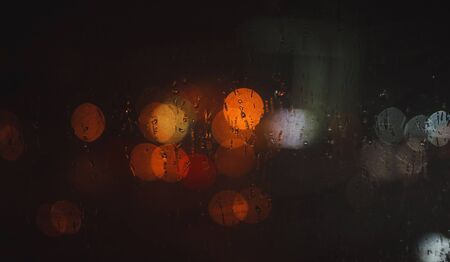 focused, blur image of rainy city at night. Light of the car in night timeの写真素材