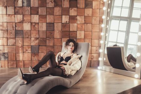 fashion studio photo of gorgeous sensual woman in luxurious pantyhose and fur coatの写真素材