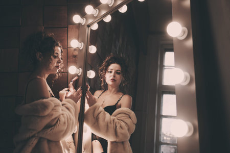 beautiful sexy lady in a fur coat stands near the mirror