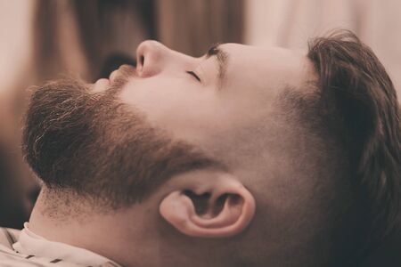 close-up of a bearded man in a barbershop after a haircutの写真素材