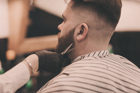 Barber cuts the beard of a brutal man in a barbershop