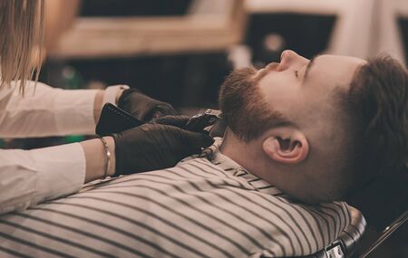 men's haircutting with beard clipper in a barber shop or hair salonの写真素材
