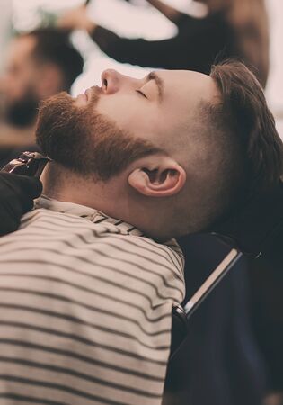 Barber shop. Bearded man in barber's chairの写真素材