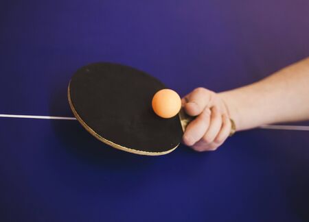hand with a table tennis racket and a ball.の写真素材
