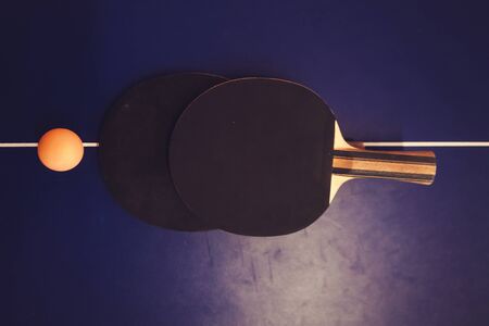 Tennis  table, two rackets and balls in a sport hallの写真素材