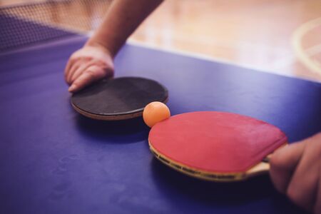 Blue table tennis . Close up net and line. Two table tennis  rackets or paddles and ball on a blue table with net backgroundの写真素材