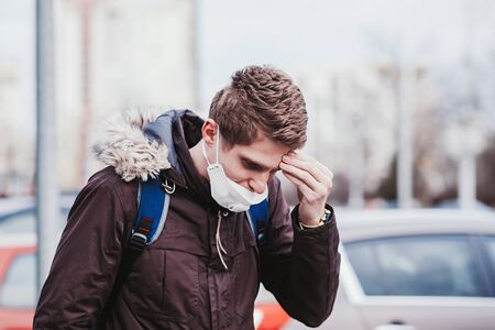 A sick man in a mask is walking through the city. The epidemic of coronavirusの写真素材